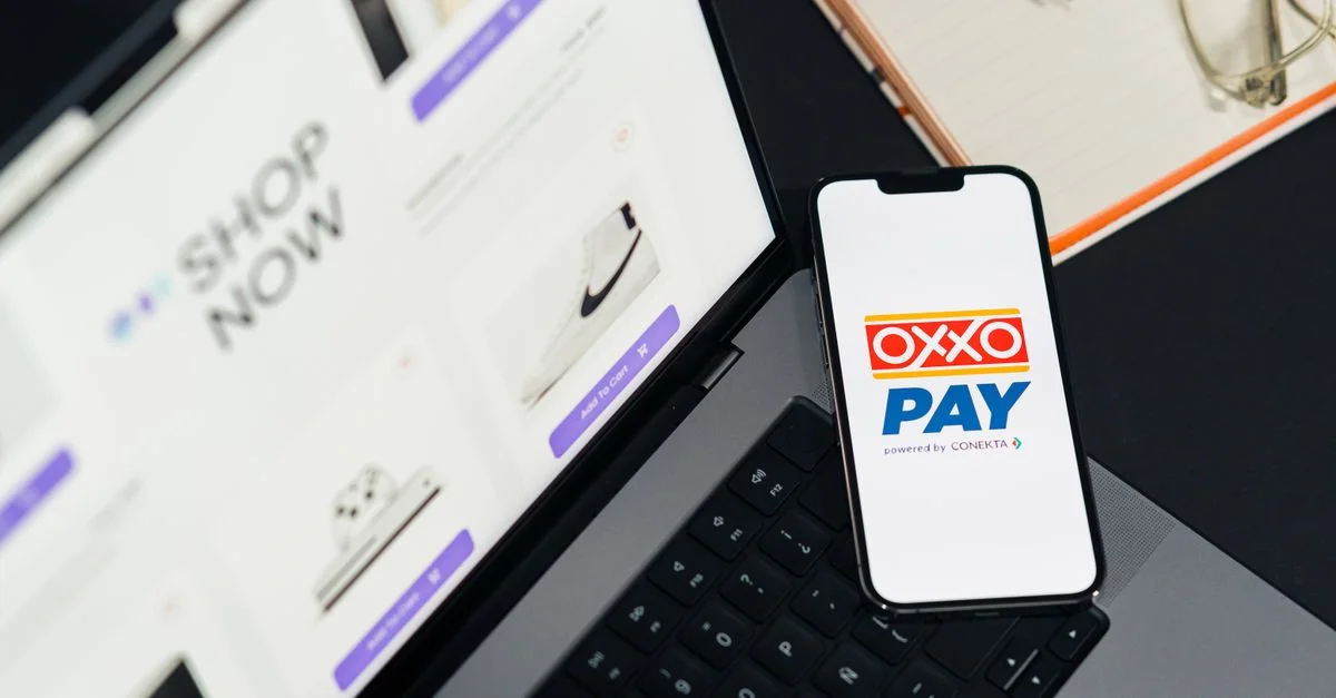 Un téléphone mobile avec OXXO Pay sur un ordinateur portable utilisé pour les achats en ligne.