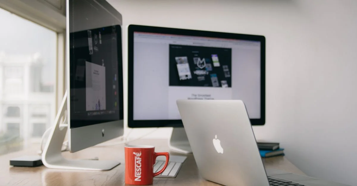Un bureau moderne lumineux avec des ordinateurs et une tasse sur un bureau.