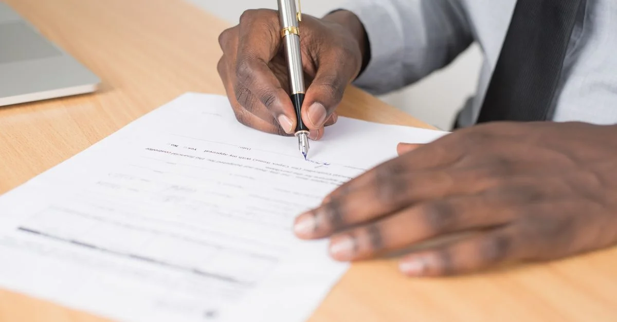 Gros plan d'un homme d'affaires signant un contrat à un bureau.