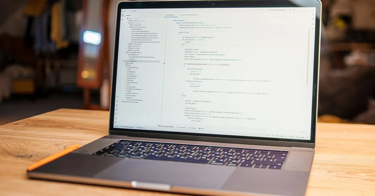 Ordinateur portable ouvert avec du code visible sur l'écran sur un bureau en bois dans un espace de travail moderne et convivial.