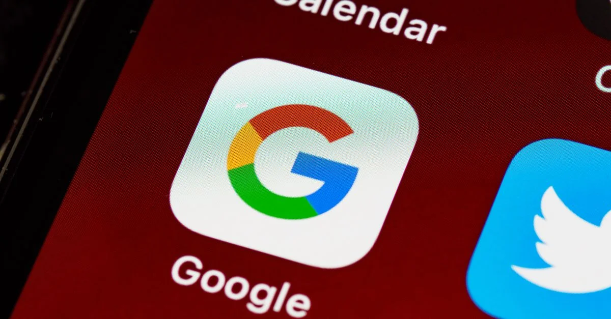 Vue macro d'un smartphone affichant l'icône Google et d'autres icônes d'application sur l'écran d'accueil.